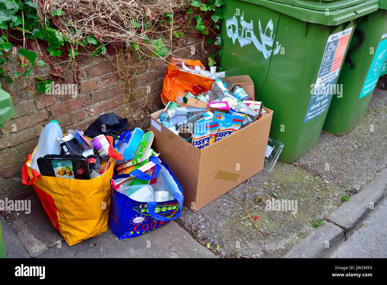 Rubbish fly tipped next to council waste collection bins Stock Photo