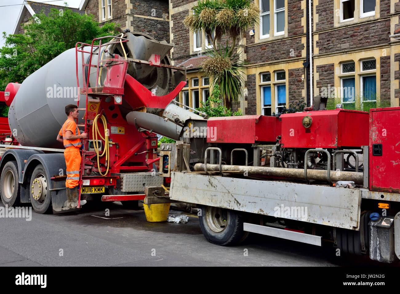 Concrete pumping truck teamed up with a ready-mix cement mixer truck for a domestic refurbishment Stock Photo