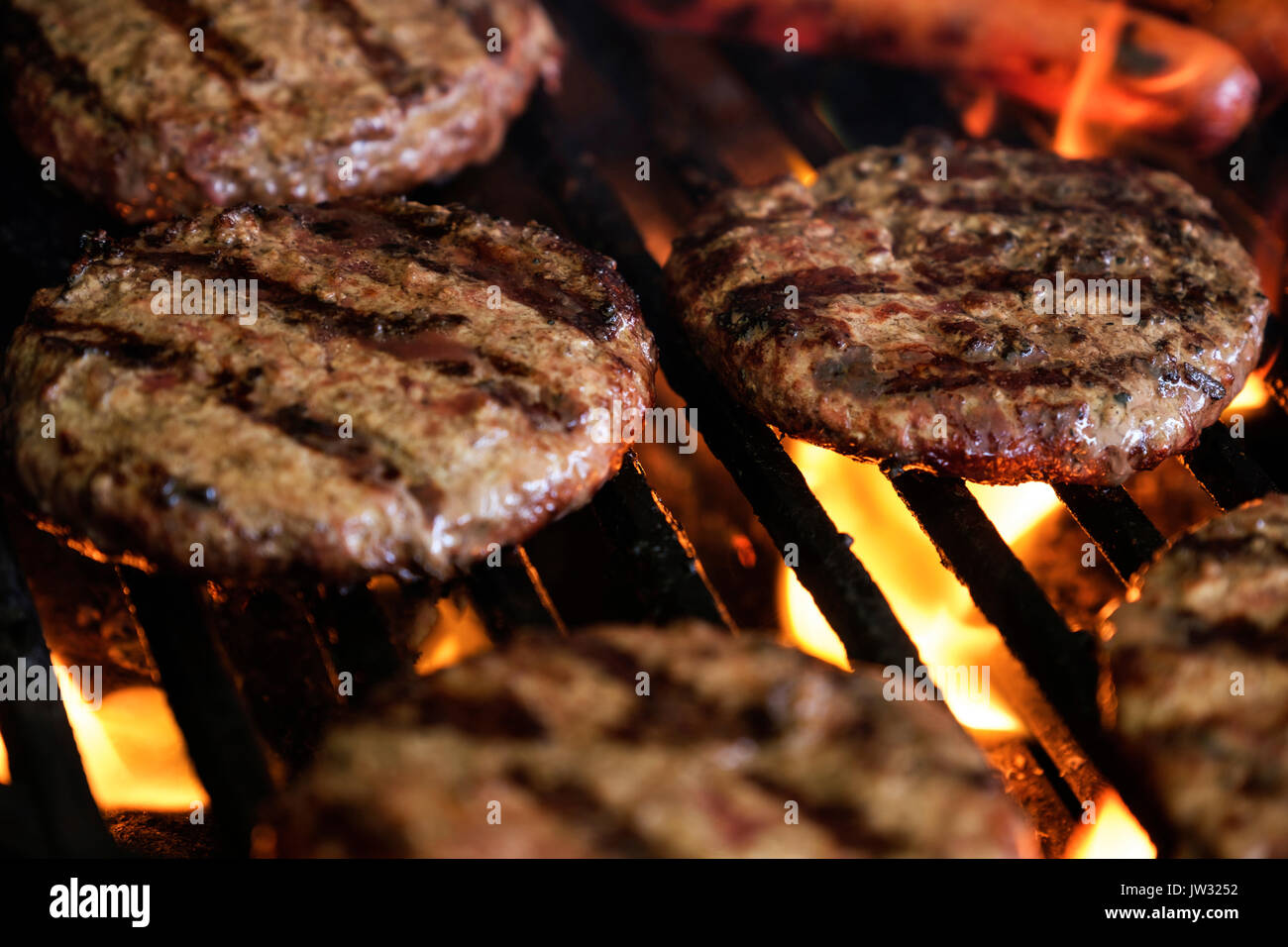 Hamburgers and hot dog on barbeque grill Stock Photo