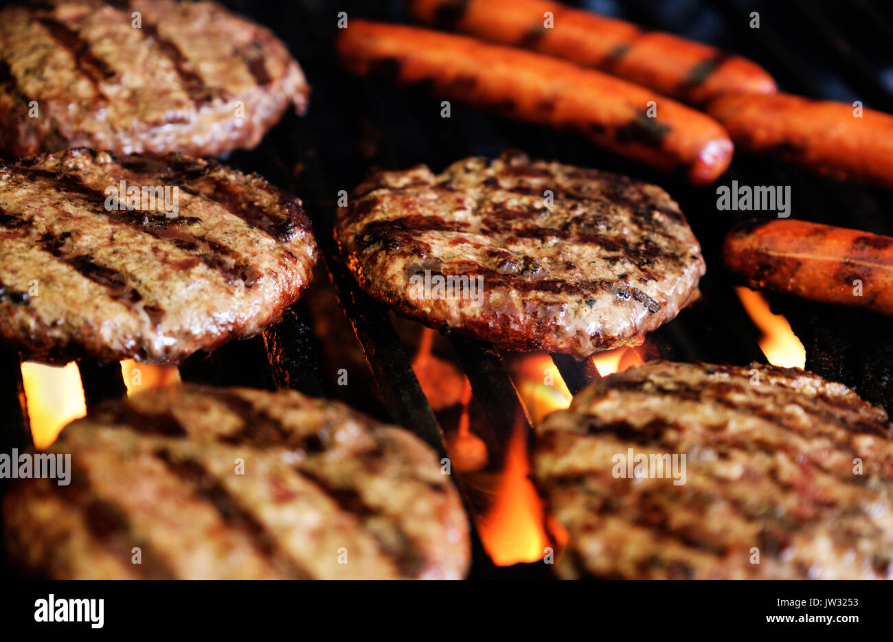 Hamburgers and hot dogs on barbeque grill Stock Photo