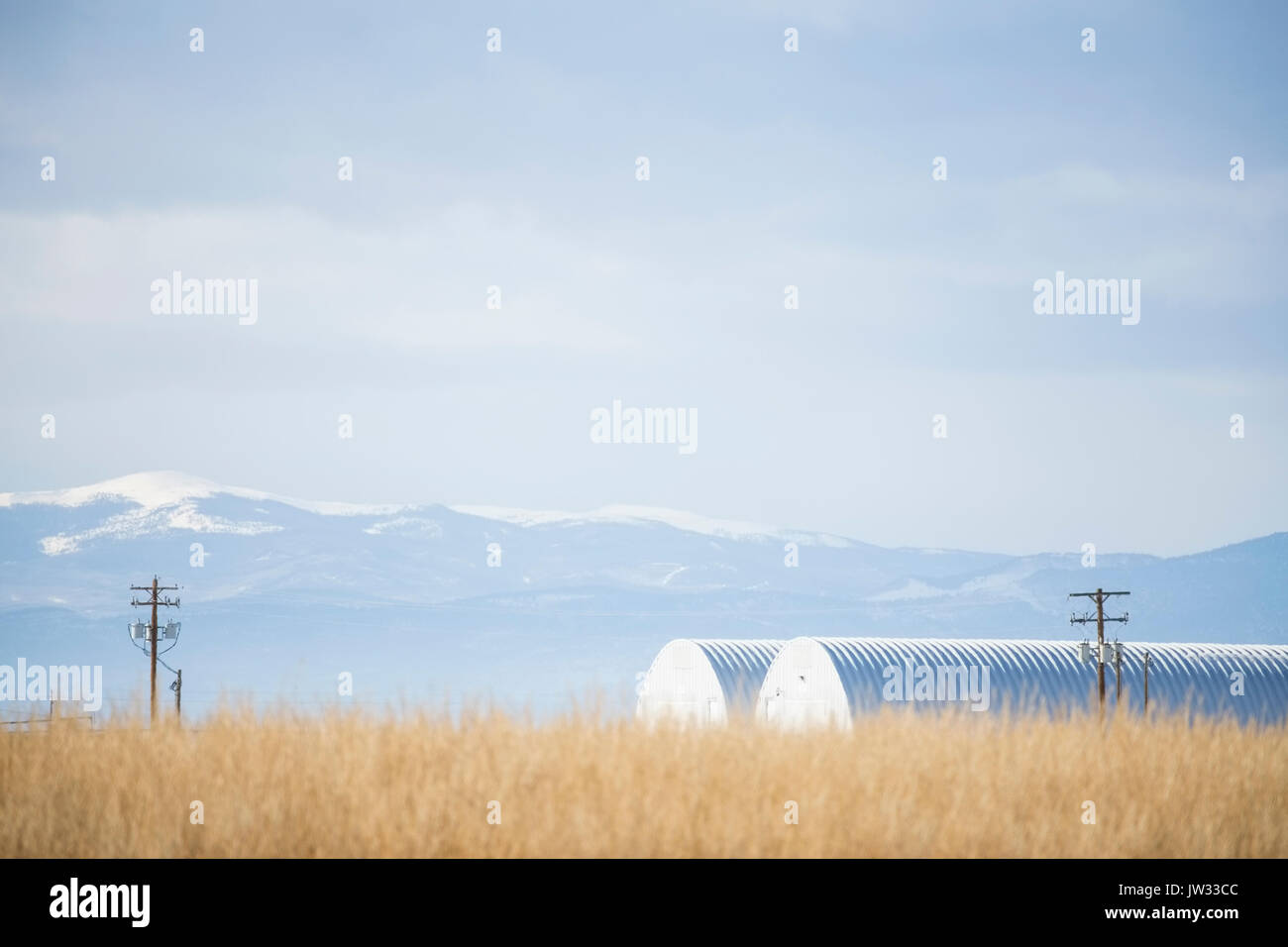 USA, Colorado, Agricultural landscape with snowcapped mountains in background Stock Photo
