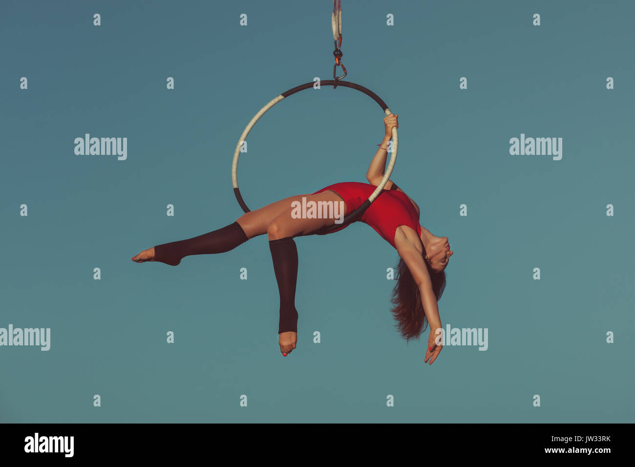 Woman is an aerial acrobat, she demonstrates the show on the hoop. Stock Photo