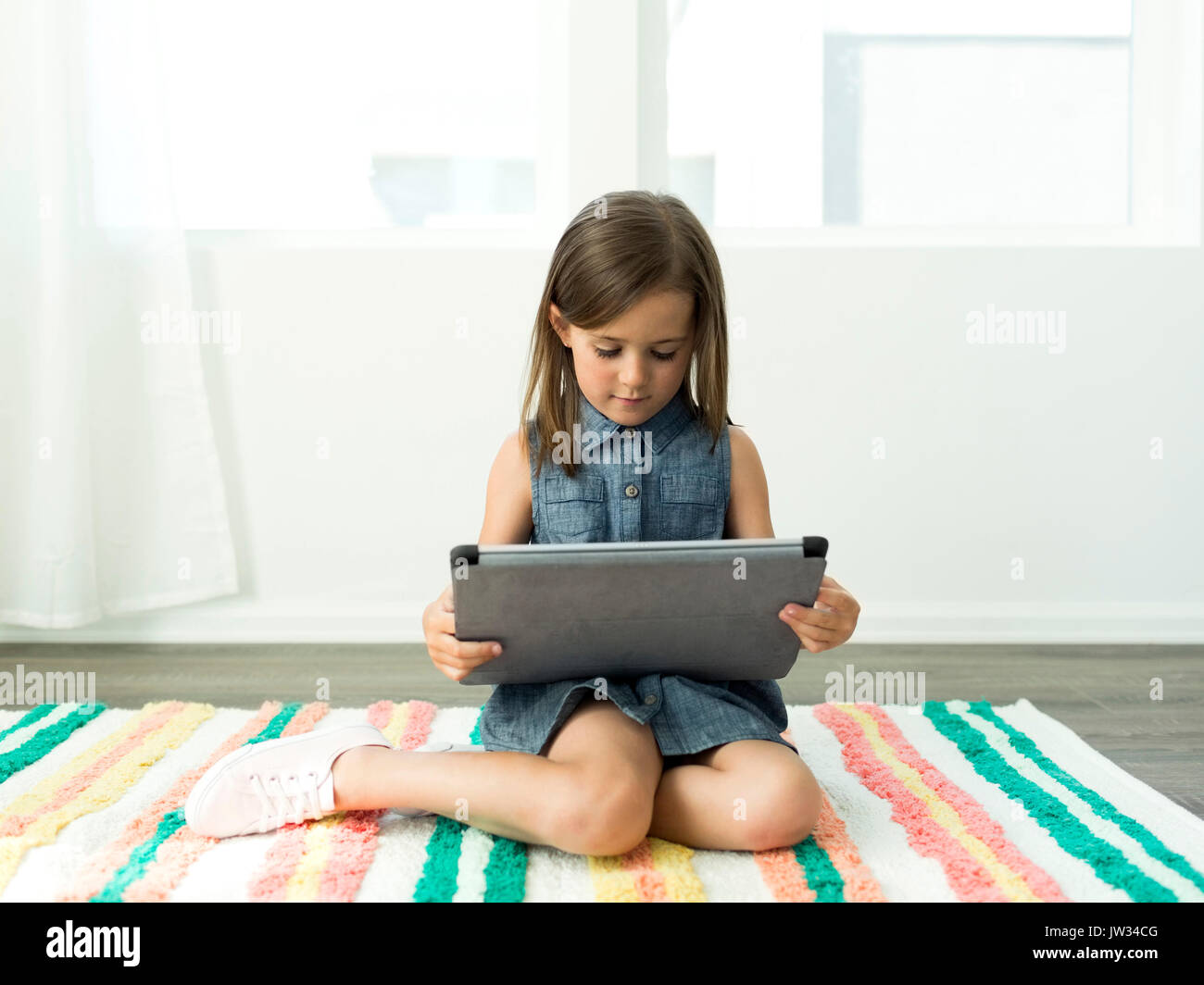 Girl (6-7) using digital tablet at home Stock Photo