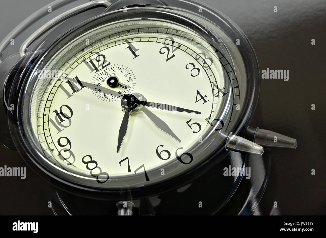 close up of   two, overlapping images with  retro alarm clocks, showing different times, horizontal, slanted Stock Photo