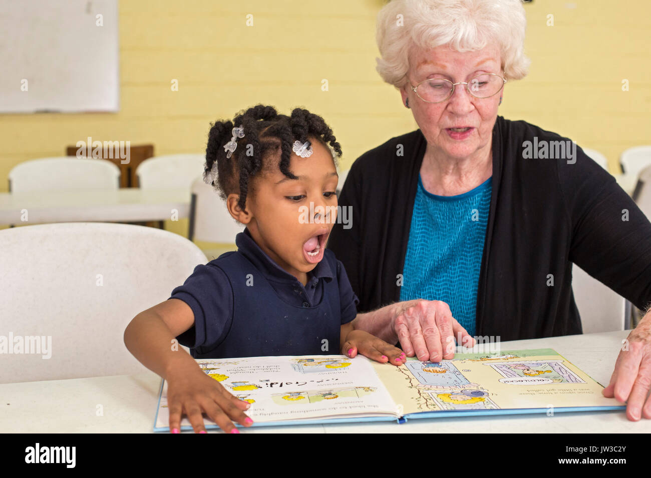 Spartanburg, South Carolina - Mary Lou Miller, a volunteer, reads a book to a child in the S.O.A.R. after school program at the Bethlehem Center, a co Stock Photo