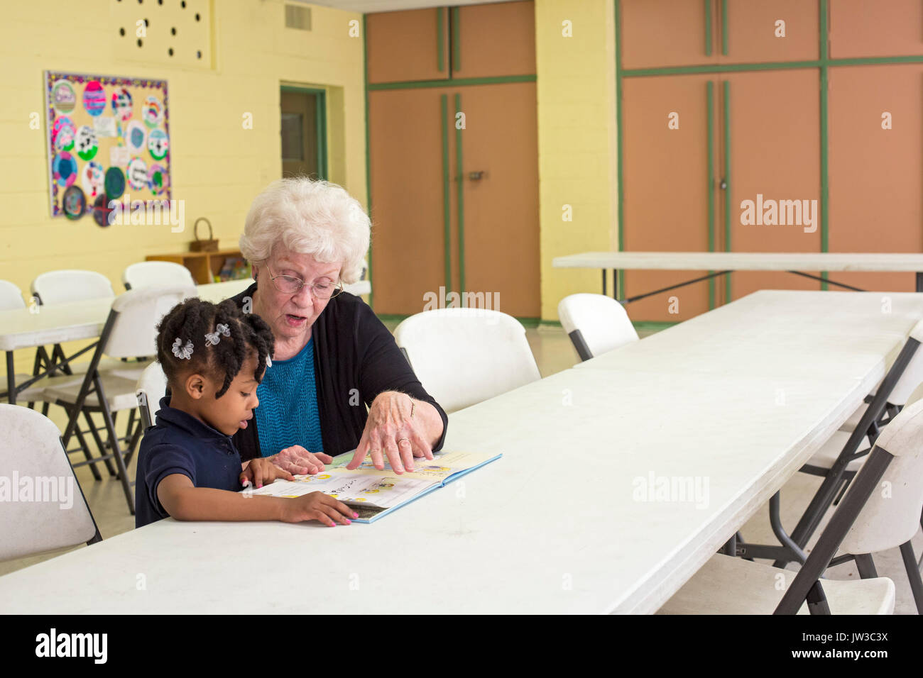 Spartanburg, South Carolina - Mary Lou Miller, a volunteer, reads a book to a child in the S.O.A.R. after school program at the Bethlehem Center, a co Stock Photo