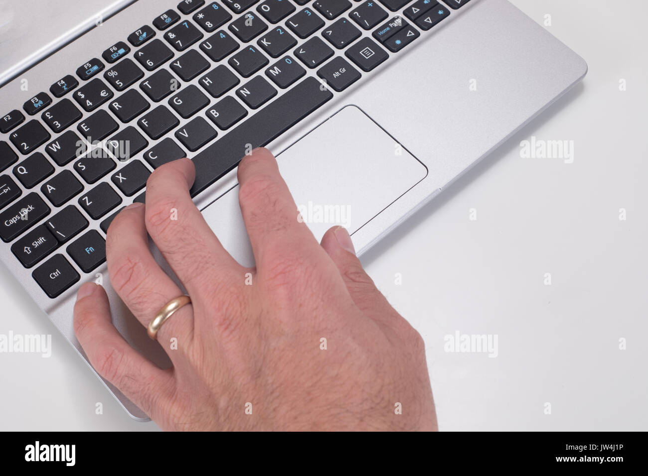 Close up of a mans hand zooming on laptop keyboard mouse tracking pad