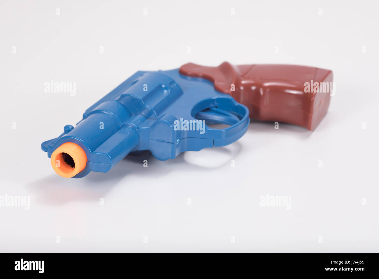 Close up of toy plastic gun barrel and white background with copy space. Stock Photo