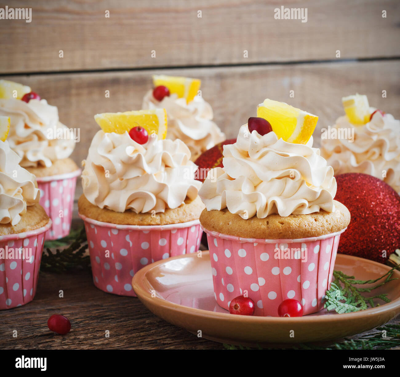 Christmas cupcakes with whipped cream topping and cranberrieson a