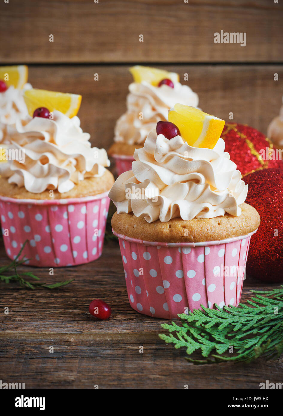 Christmas cupcakes with whipped cream topping and cranberrieson a