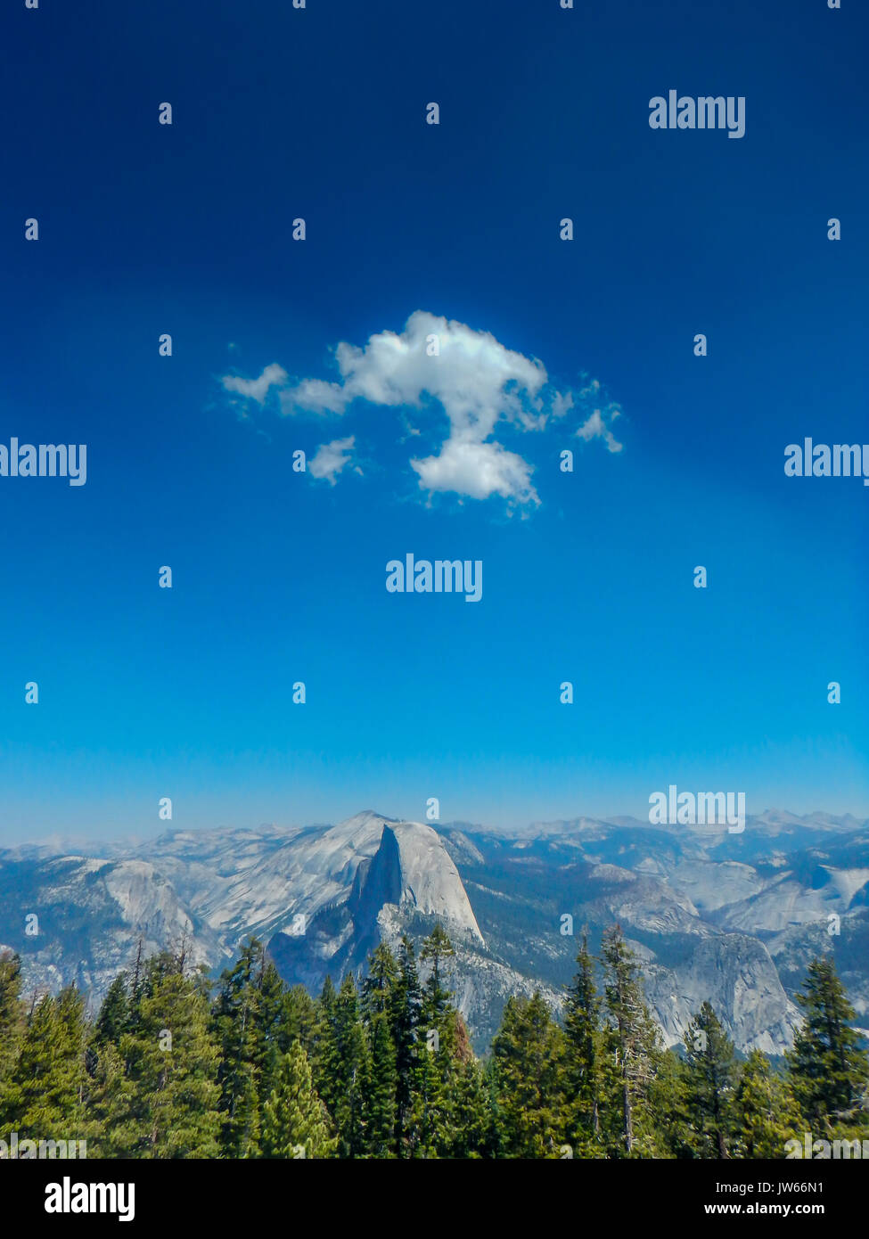 White cloud against a dark blue sky over Half Dome in Yosemite Valley, Yosemite National Park, California Stock Photo