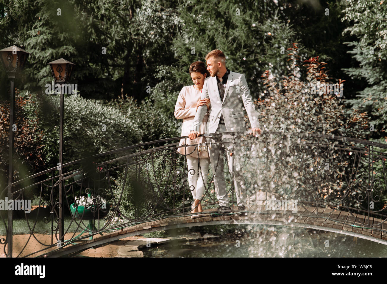 young beautiful couple walking in the Park and stands on the bridge Stock Photo