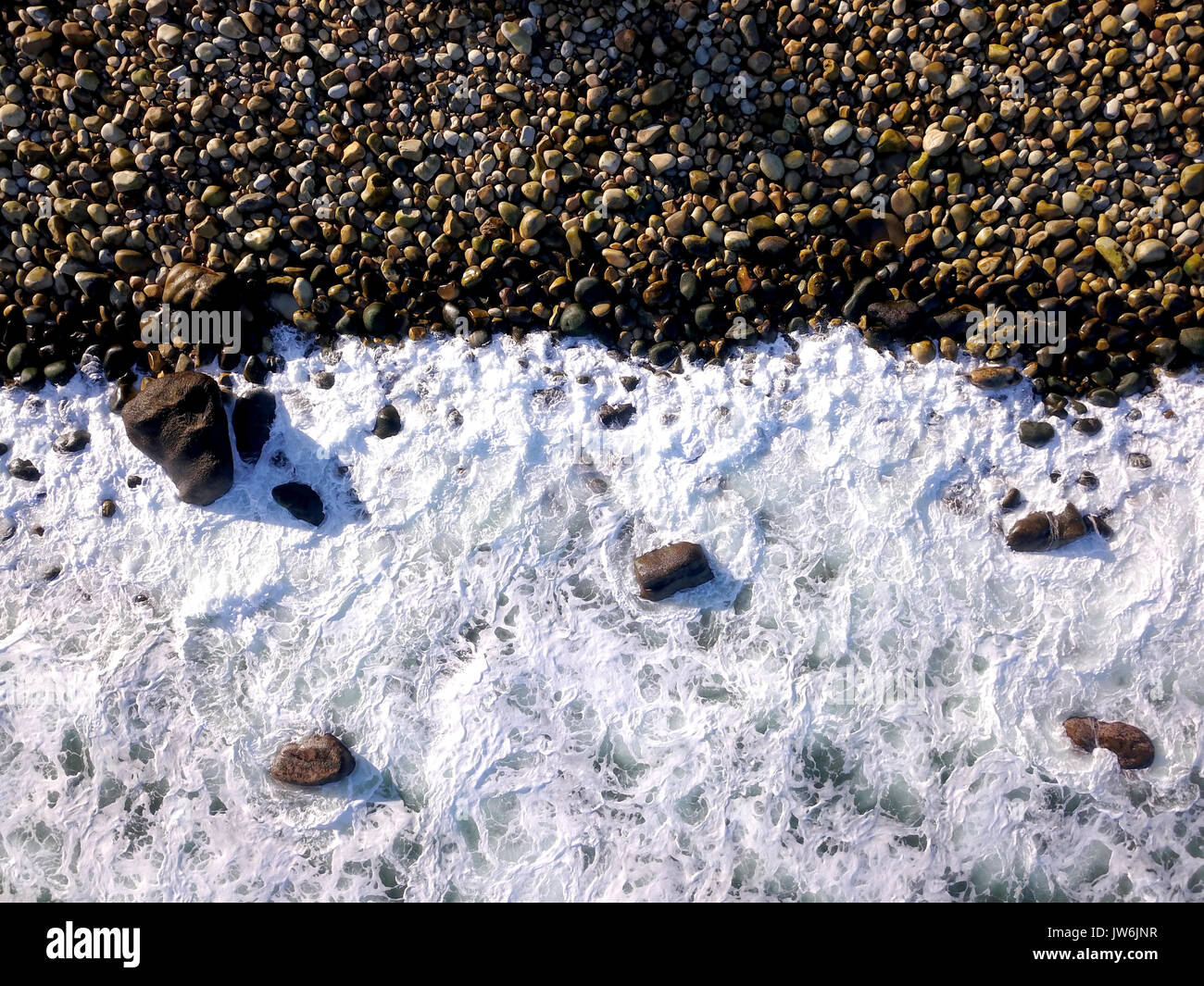 Aerial over rocky coastline and waves Stock Photo