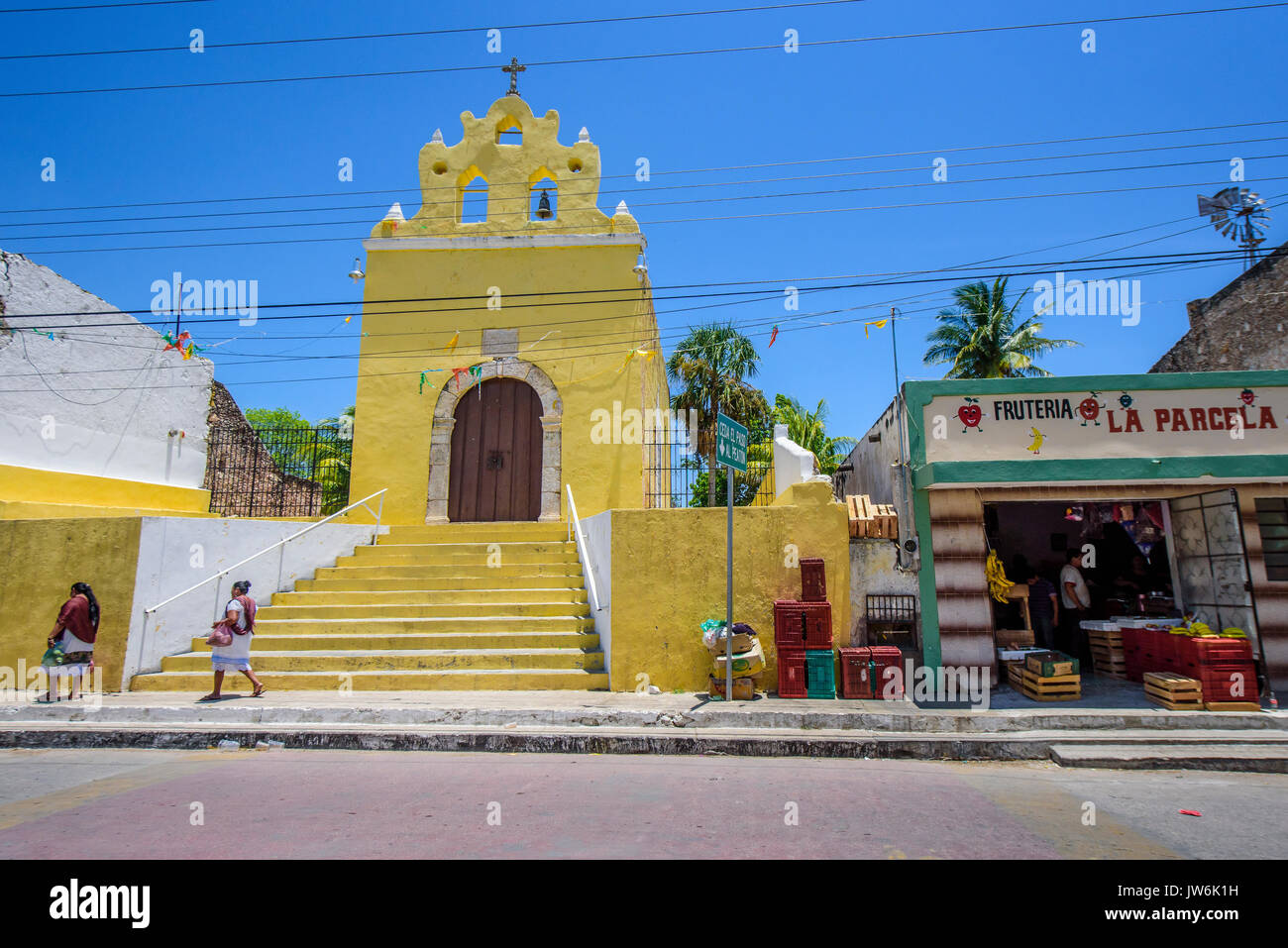 Mayan women walking in front of the Chapel in Acanceh, Yucatan state, Mexico Stock Photo