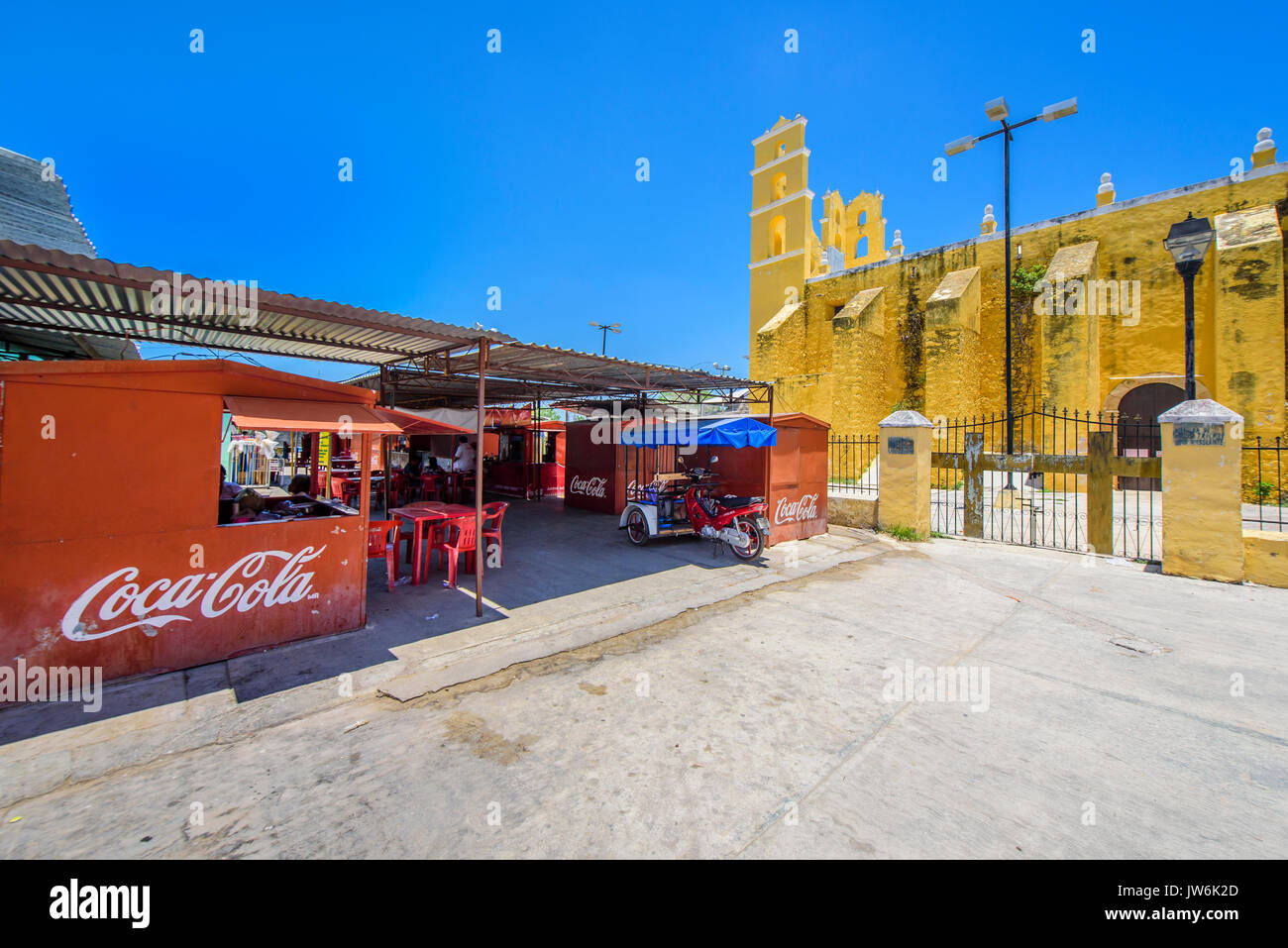 Bar in the Central market with the Church Nuestra Senora de la Natividad at background,  in Acanceh, Yucatan state, Mexico Stock Photo