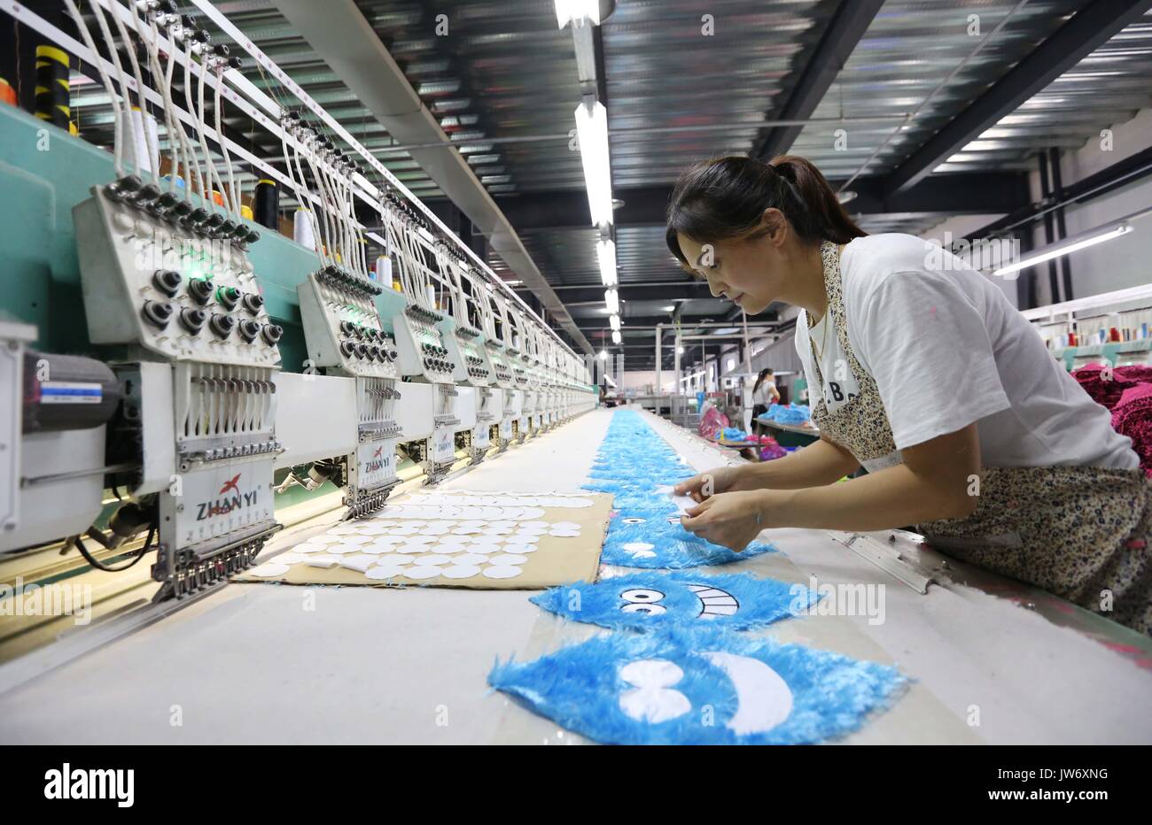 Jiaozuo. 11th Aug, 2017. A woman works in an assembly line in a toy