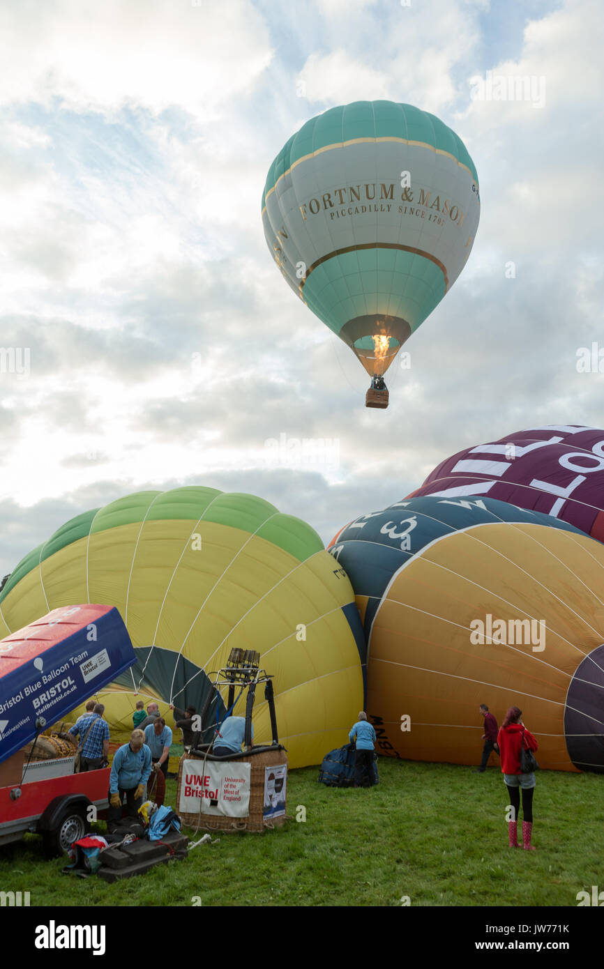 Ashton Court, Bristol, UK. 12 August 2017.  After the disappointing rain on Friday evening, the weather improves to allow 28 hot air balloons to fly over Bristol before the launch was curtailed due to worsening weather conditions. The third planned ascent at this year’s Bristol International Balloon Fiesta was in front of a large crowds at Ashton Court, Bristol. Stock Photo
