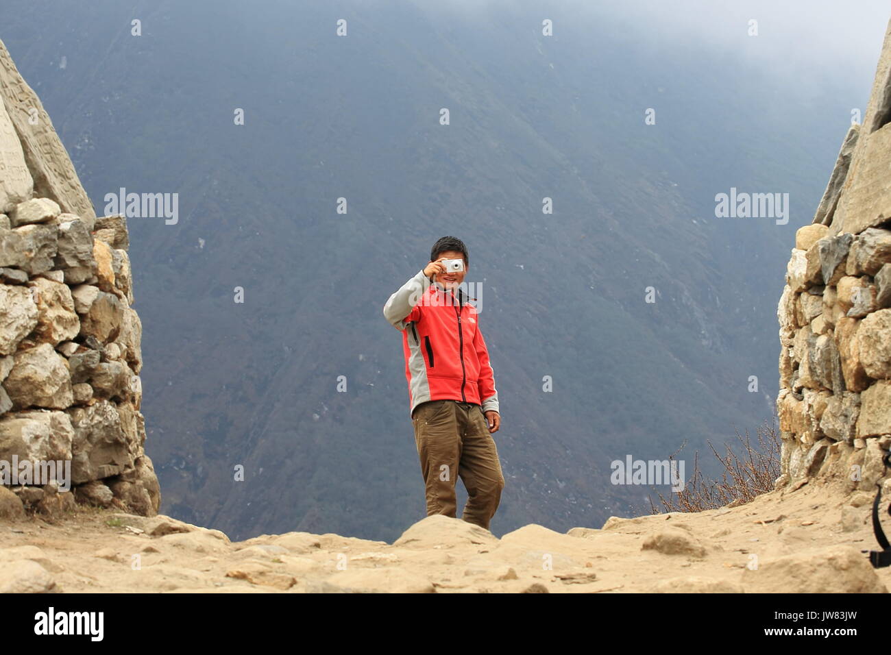 Young Nepali testing his Photography skills at high altitude near Nameche Bazaar village Stock Photo
