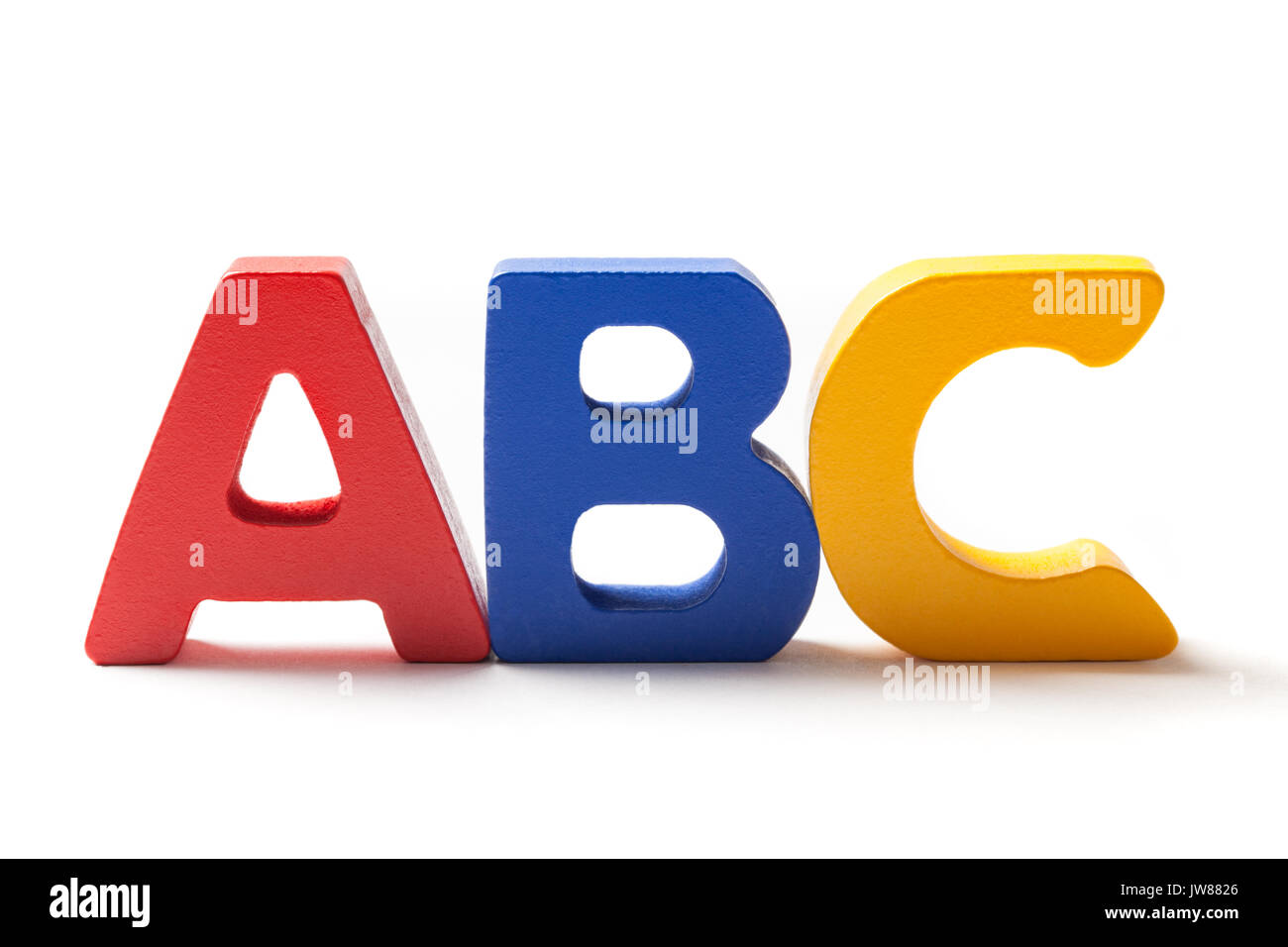 Wooden colorful alphabet letters A, B and C arranged in line on white background. Stock Photo