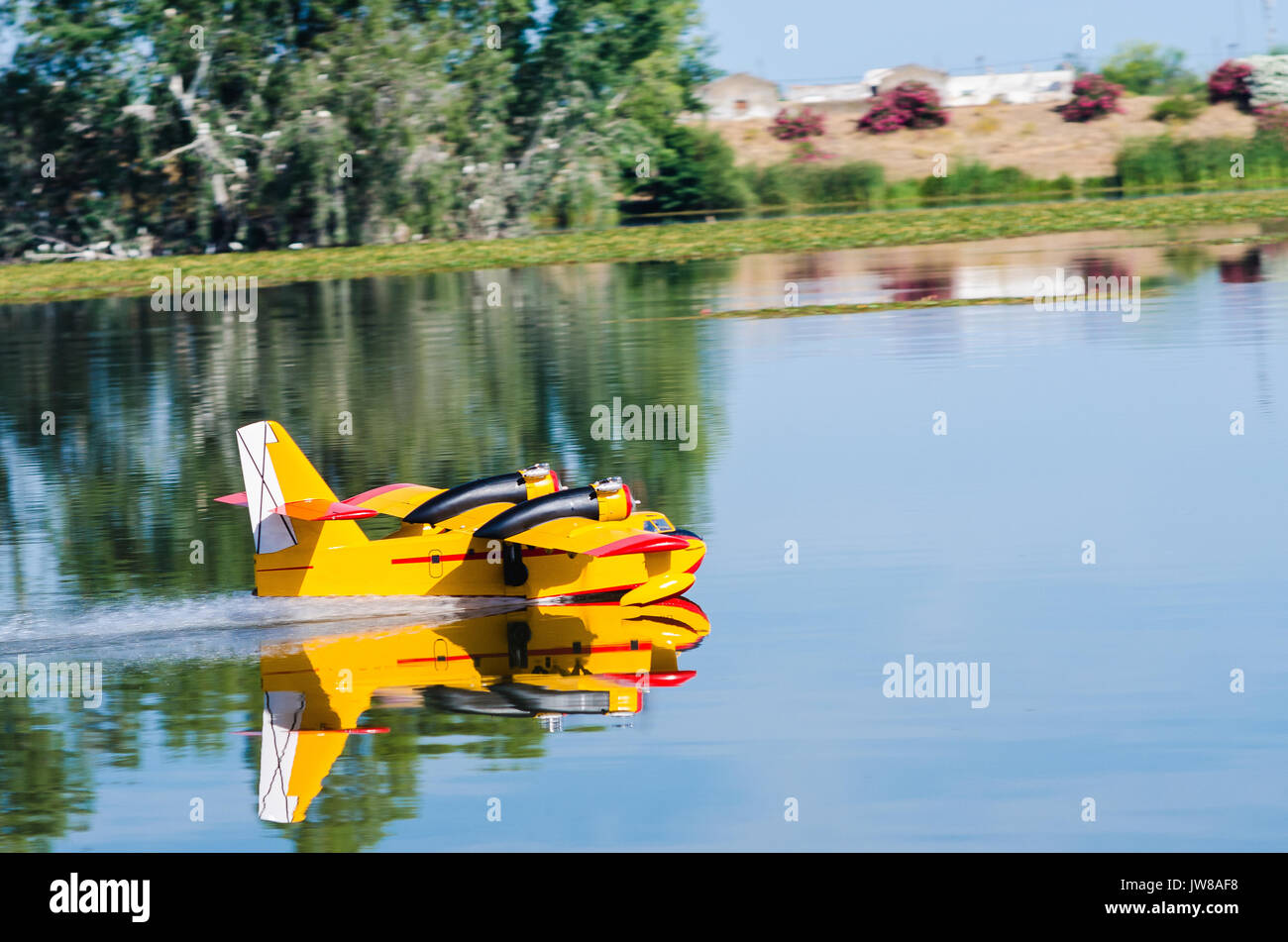 A floating Radio controlled model hydroplane speeds up to take off on Guadiana river, Badajoz Stock Photo