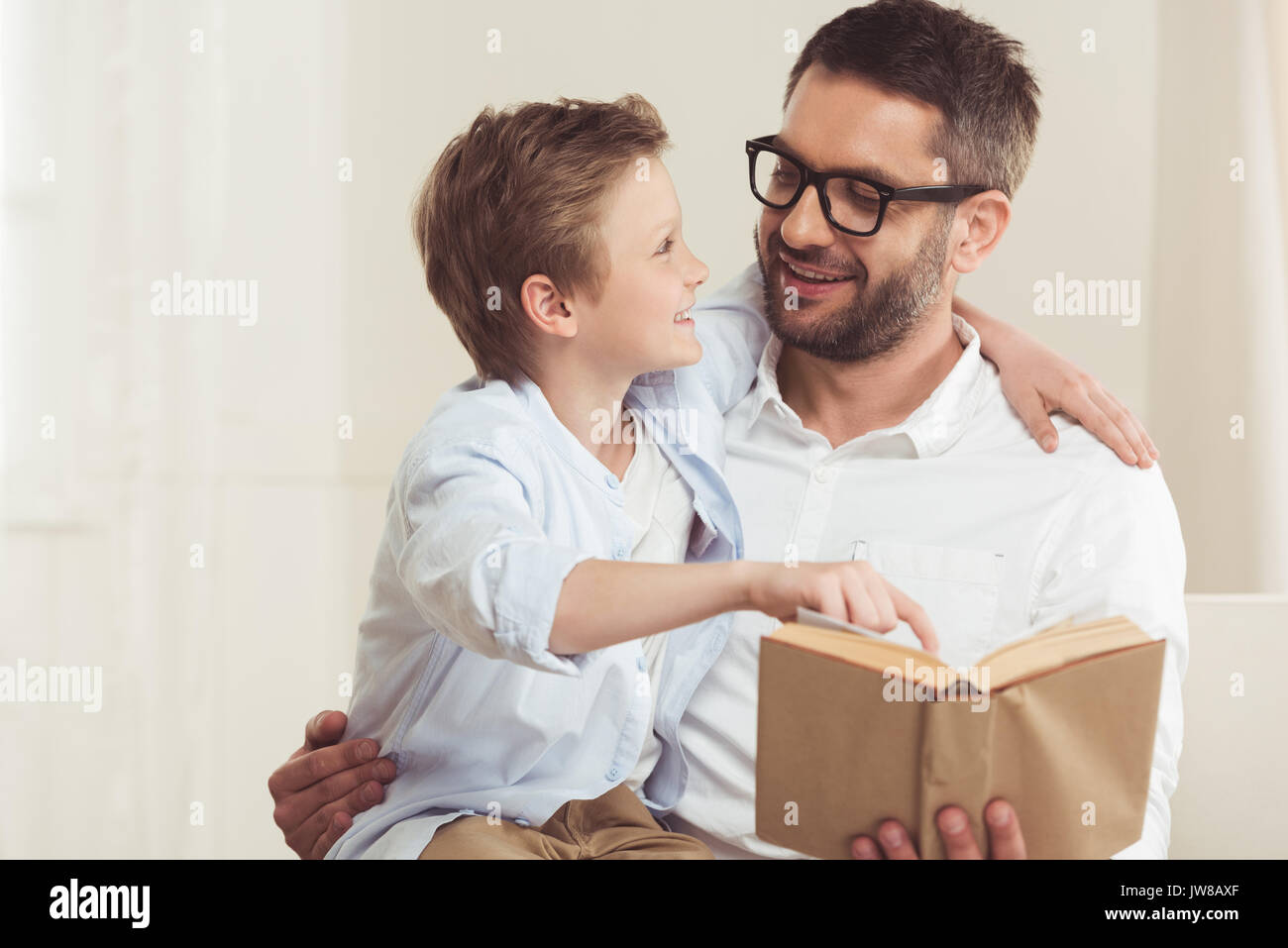 portrait of father and little son reading book at home Stock Photo