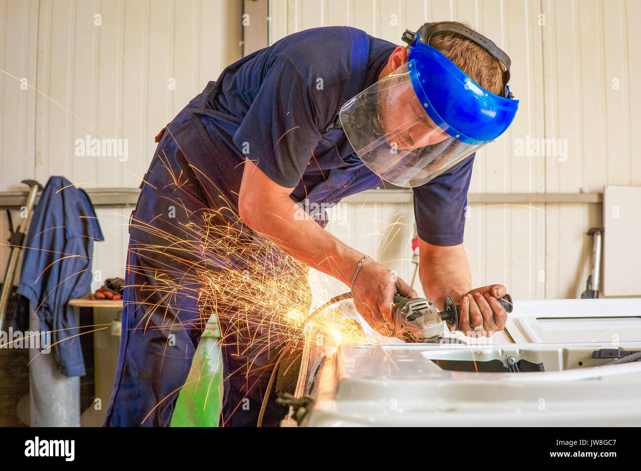 Closeup of worker cutting metal with grinder. Sparks while grinding