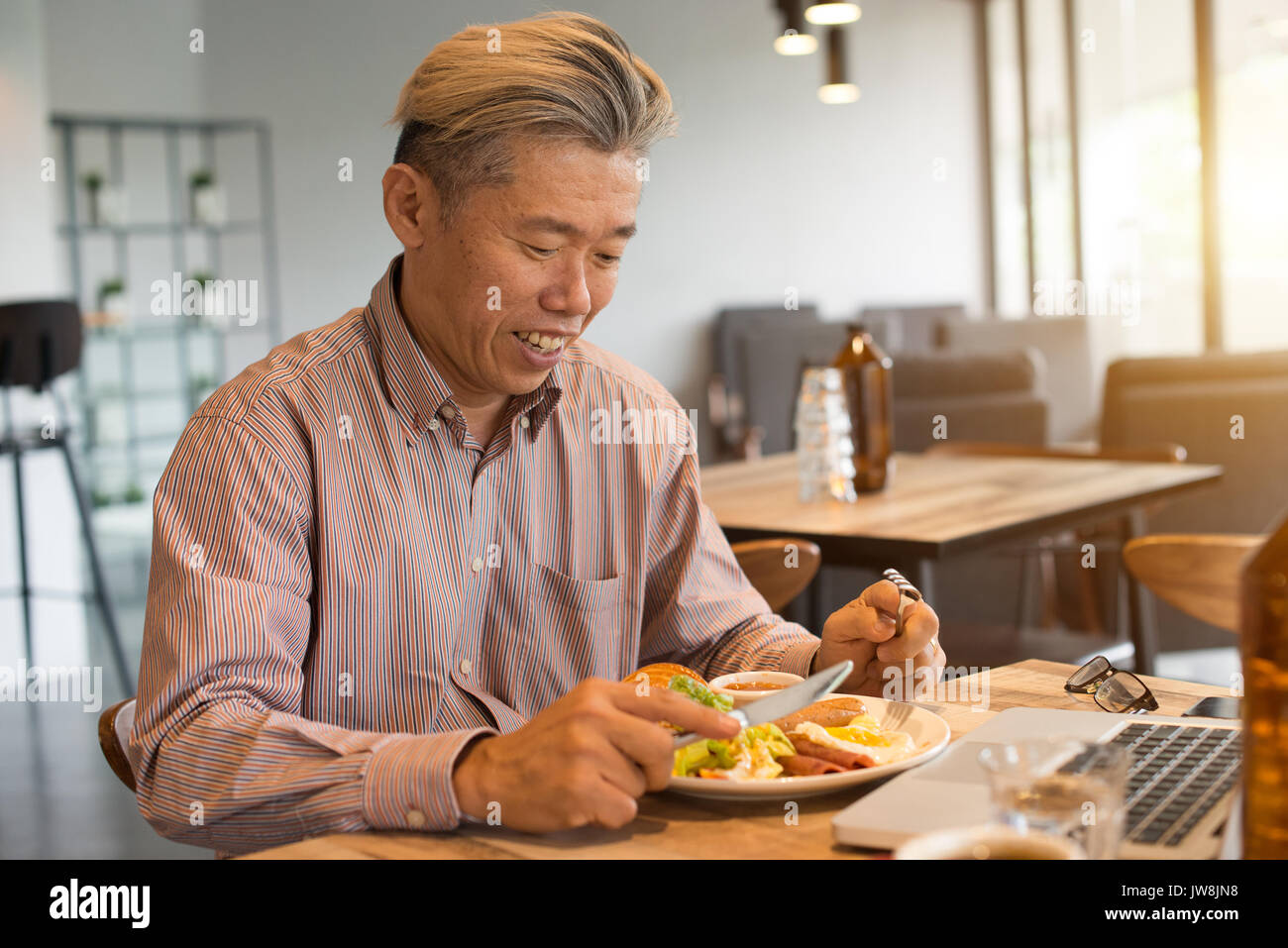 matured asian business male having breakfast Stock Photo