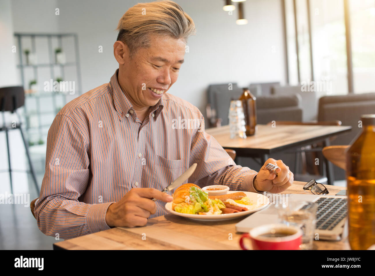 matured asian business male having breakfast Stock Photo