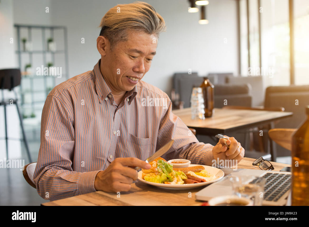 matured asian business male having breakfast Stock Photo