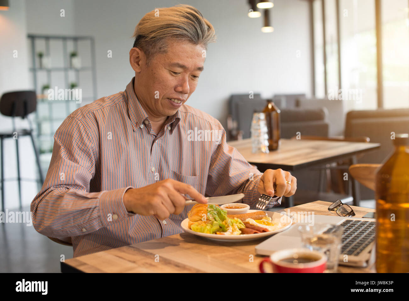 matured asian business male having breakfast Stock Photo