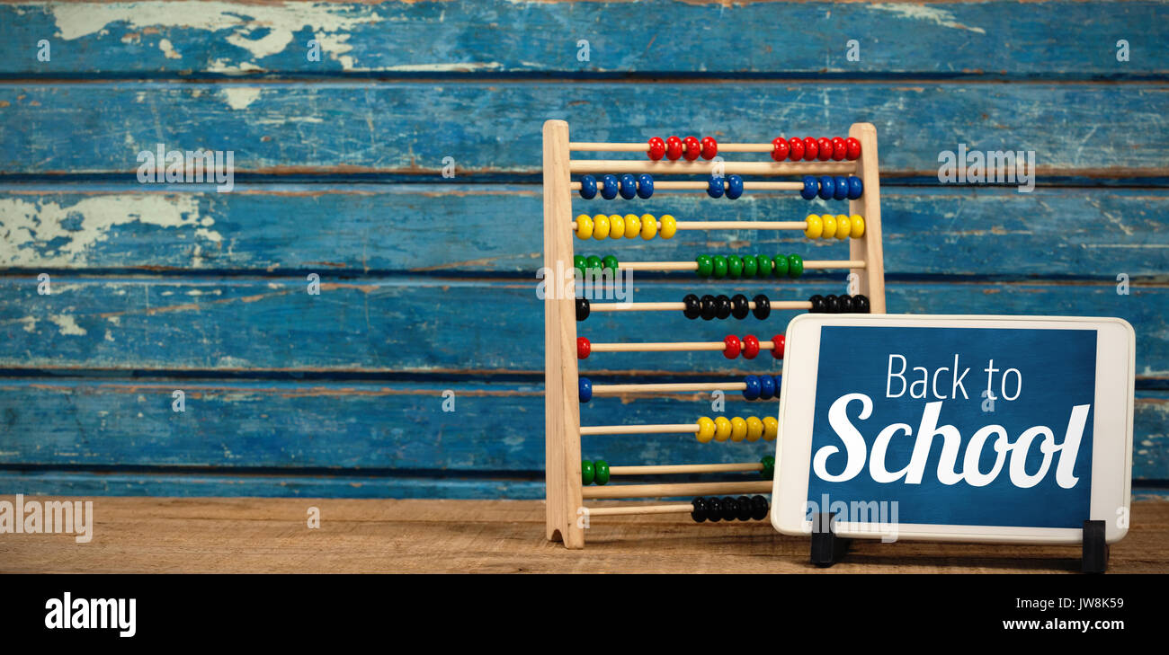 Back to school text over white background against digital tablet by abacus on table Stock Photo