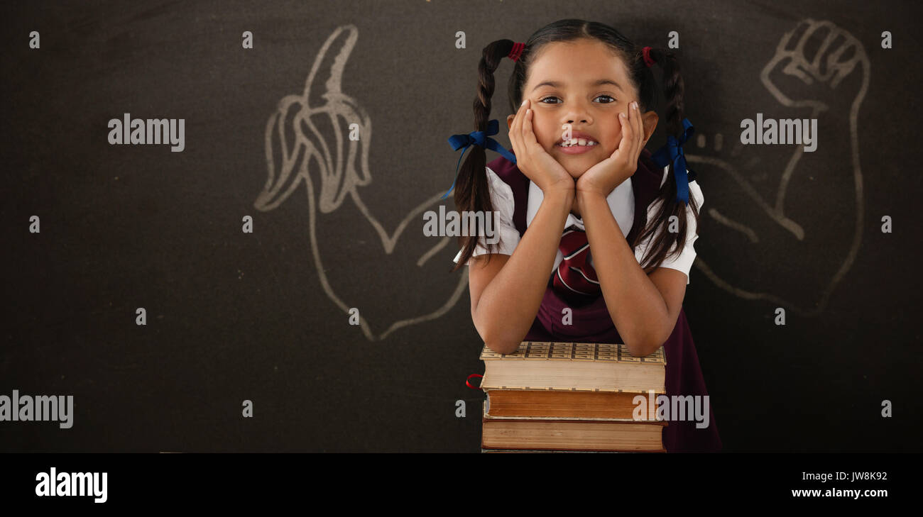 Schoolgirl leaning on stack of books against blackboard Stock Photo - Alamy
