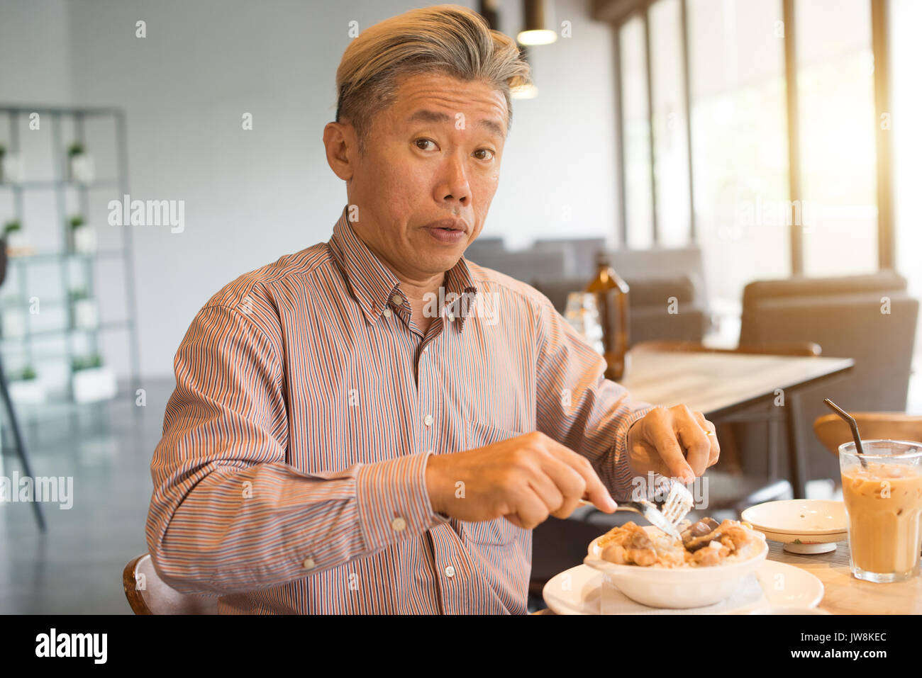 matured asian business male having breakfast Stock Photo