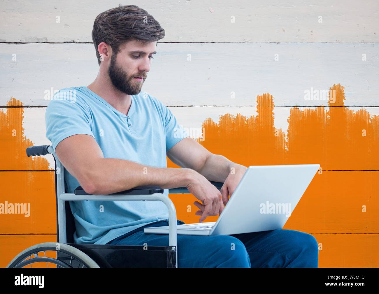 Digital composite of Disabled man in wheelchair with bright painted orange background Stock Photo