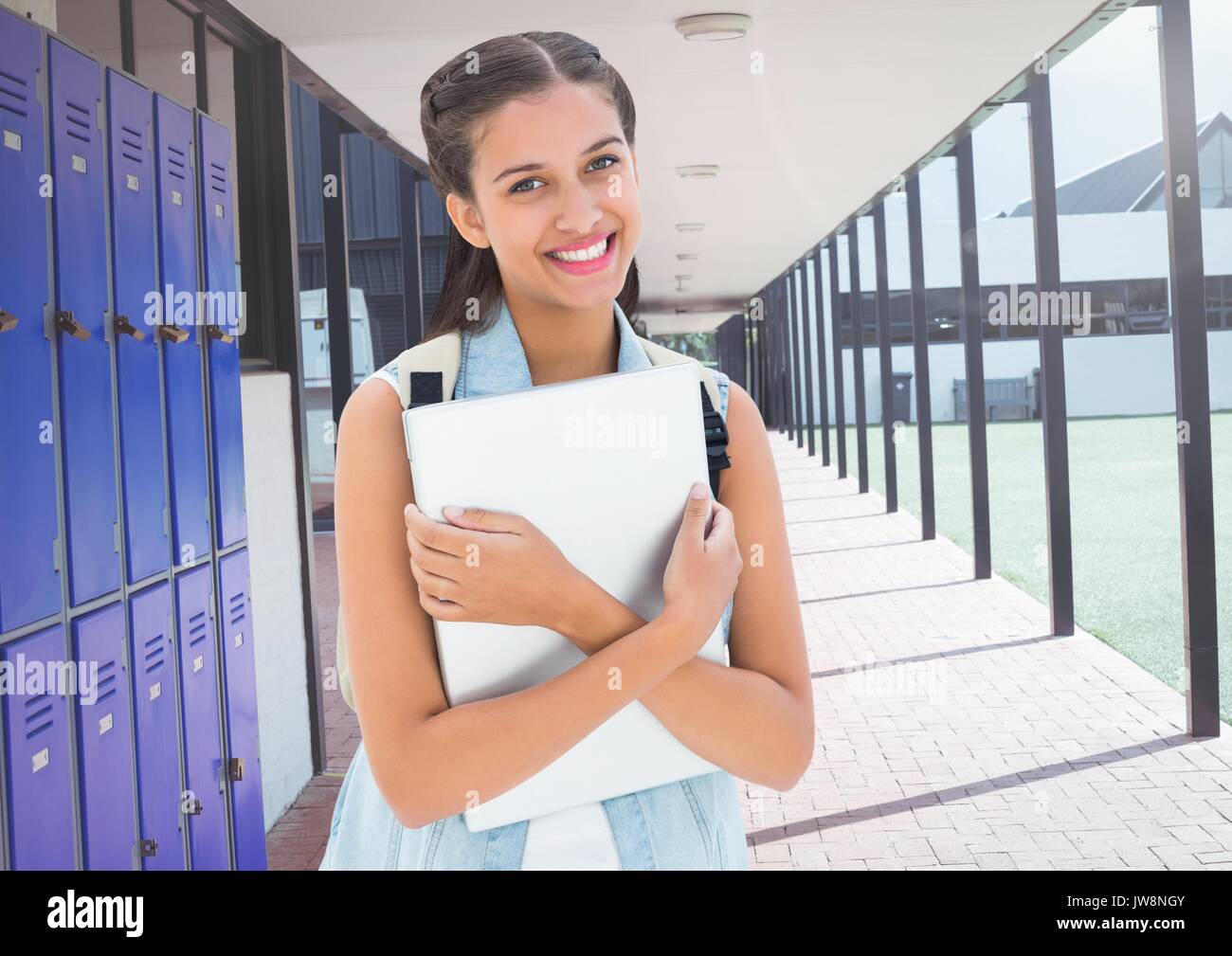 Digital composite of female student holding file in front of lockers Stock Photo