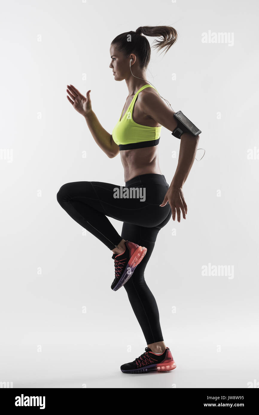 Desaturated back lit silhouette of athletic woman runner motion while  sprinting fast over gray studio background Stock Photo - Alamy