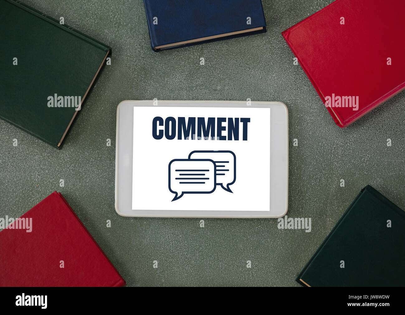 Digital composite of Comment text and chat graphic on tablet screen with books Stock Photo