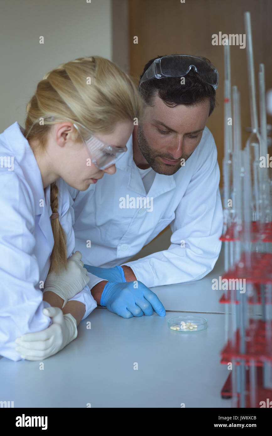 Attentive university students doing a experiment in laboratory Stock Photo