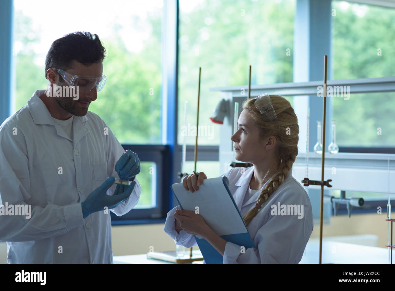 Attentive university students doing a experiment in laboratory Stock Photo