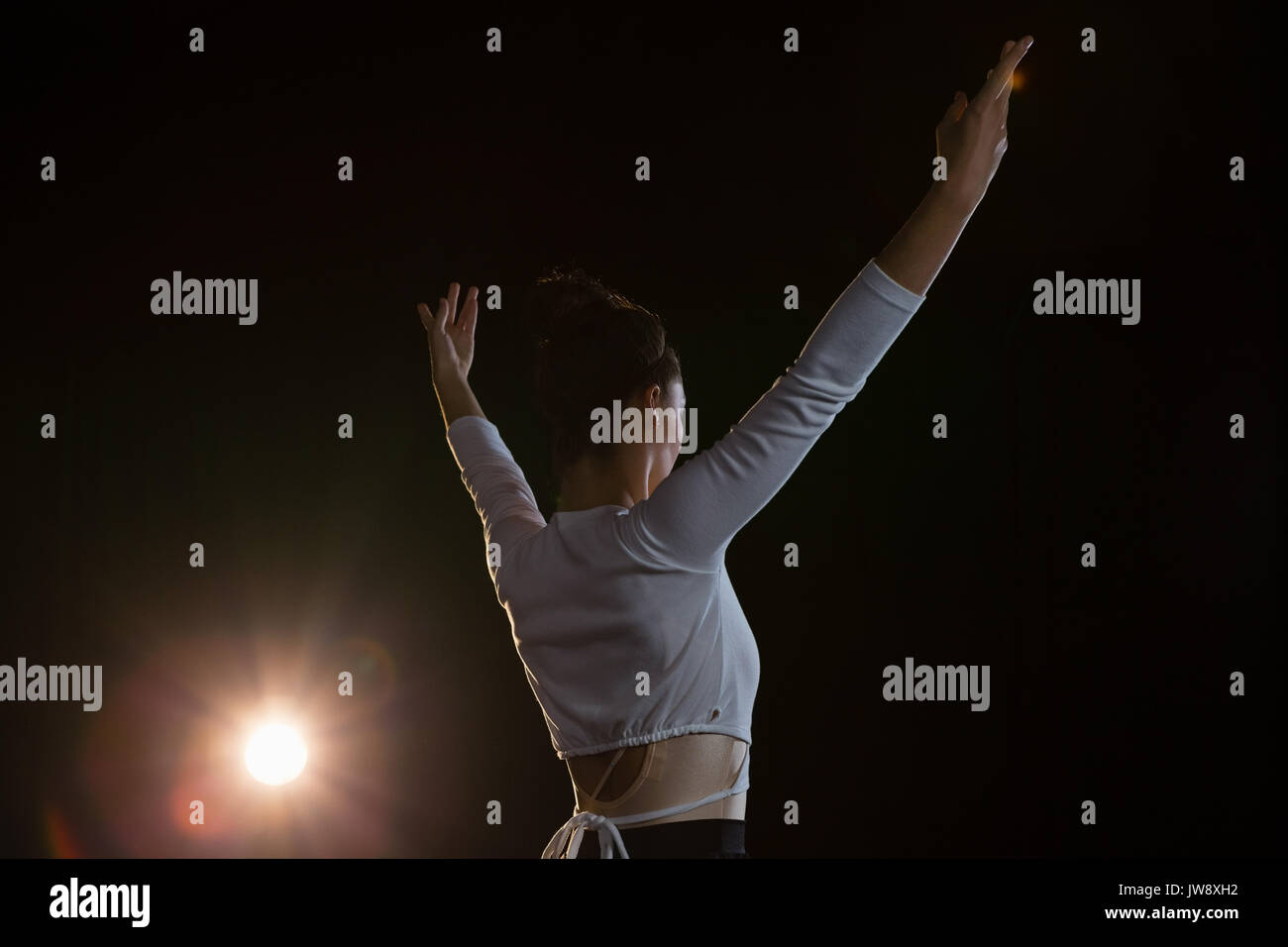 Rear view of ballerina practicing ballet dance on the stage Stock Photo