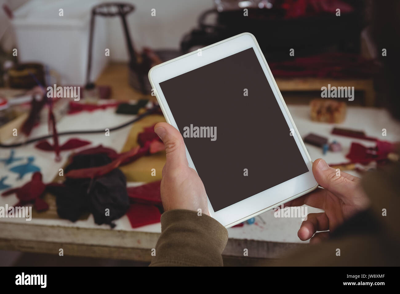 Mid-section of craftsman using digital tablet in workshop Stock Photo