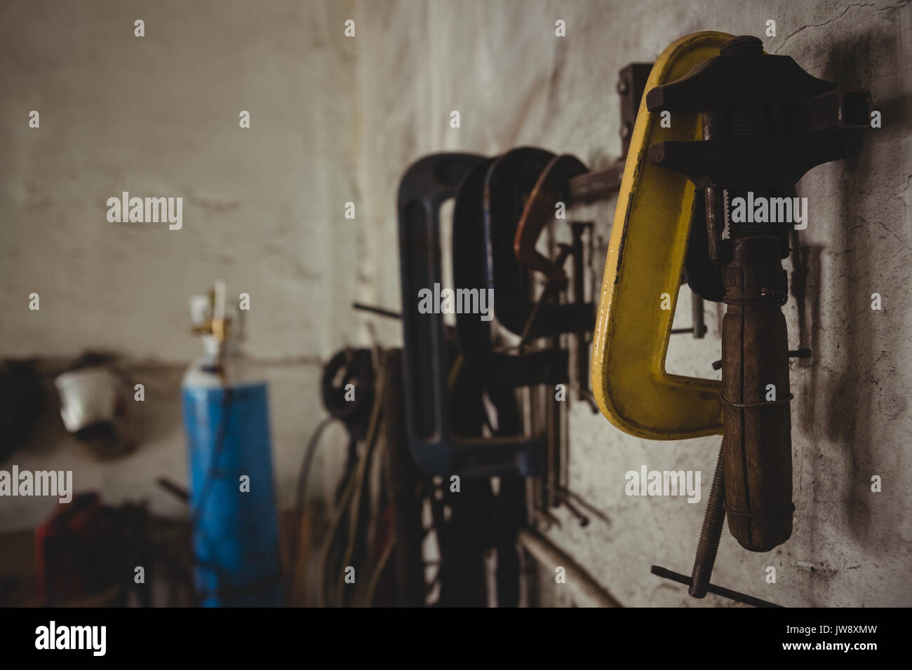 Tools hanging on wall in workshop Stock Photo