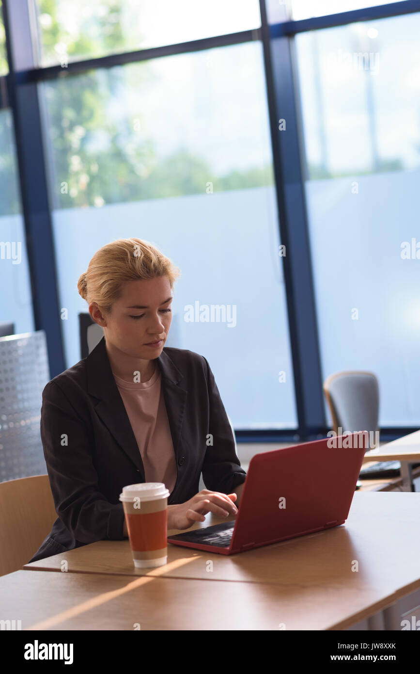 Attentive university student using laptop in college Stock Photo