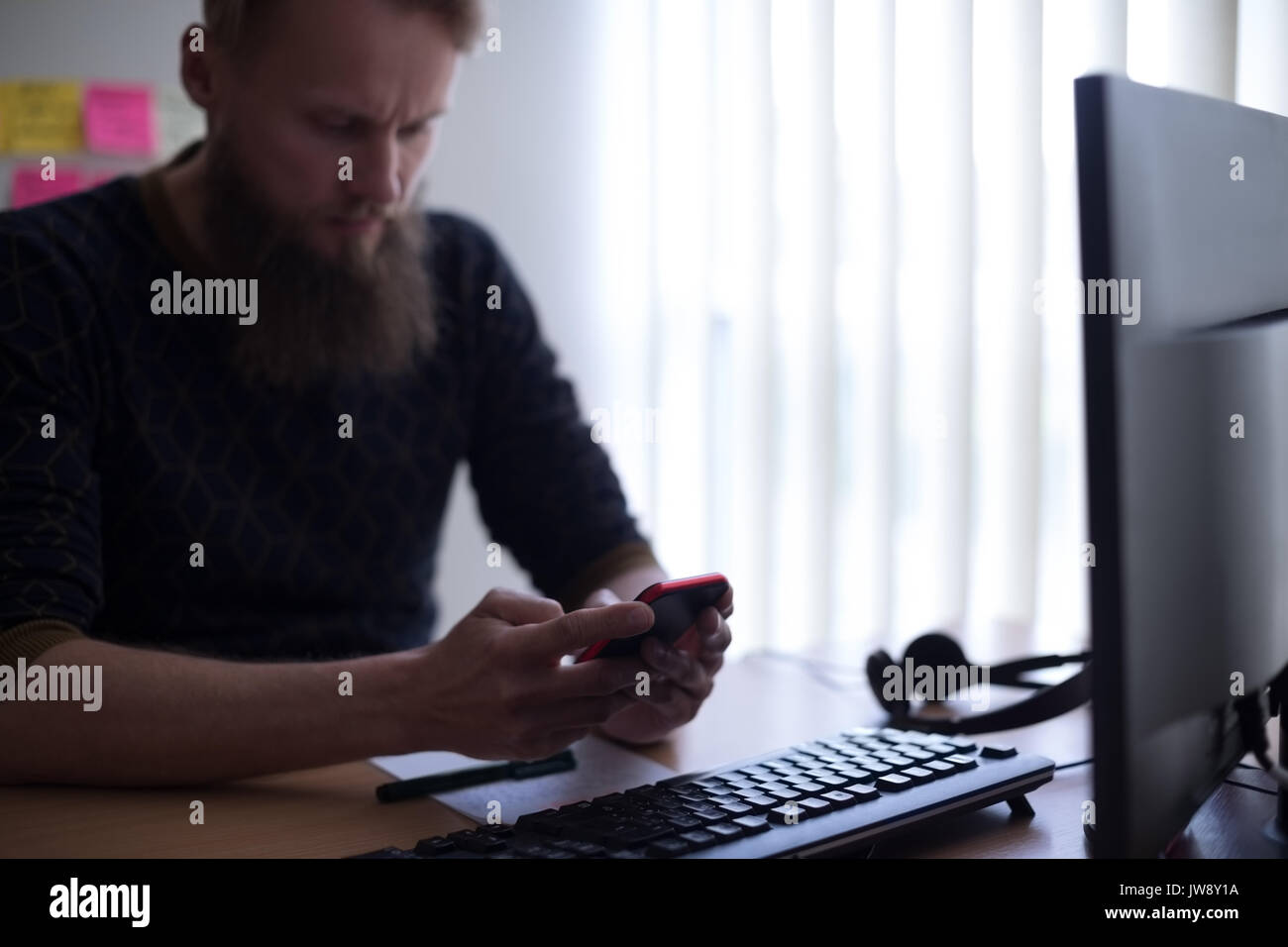 Executive using mobile phone at desk in office Stock Photo