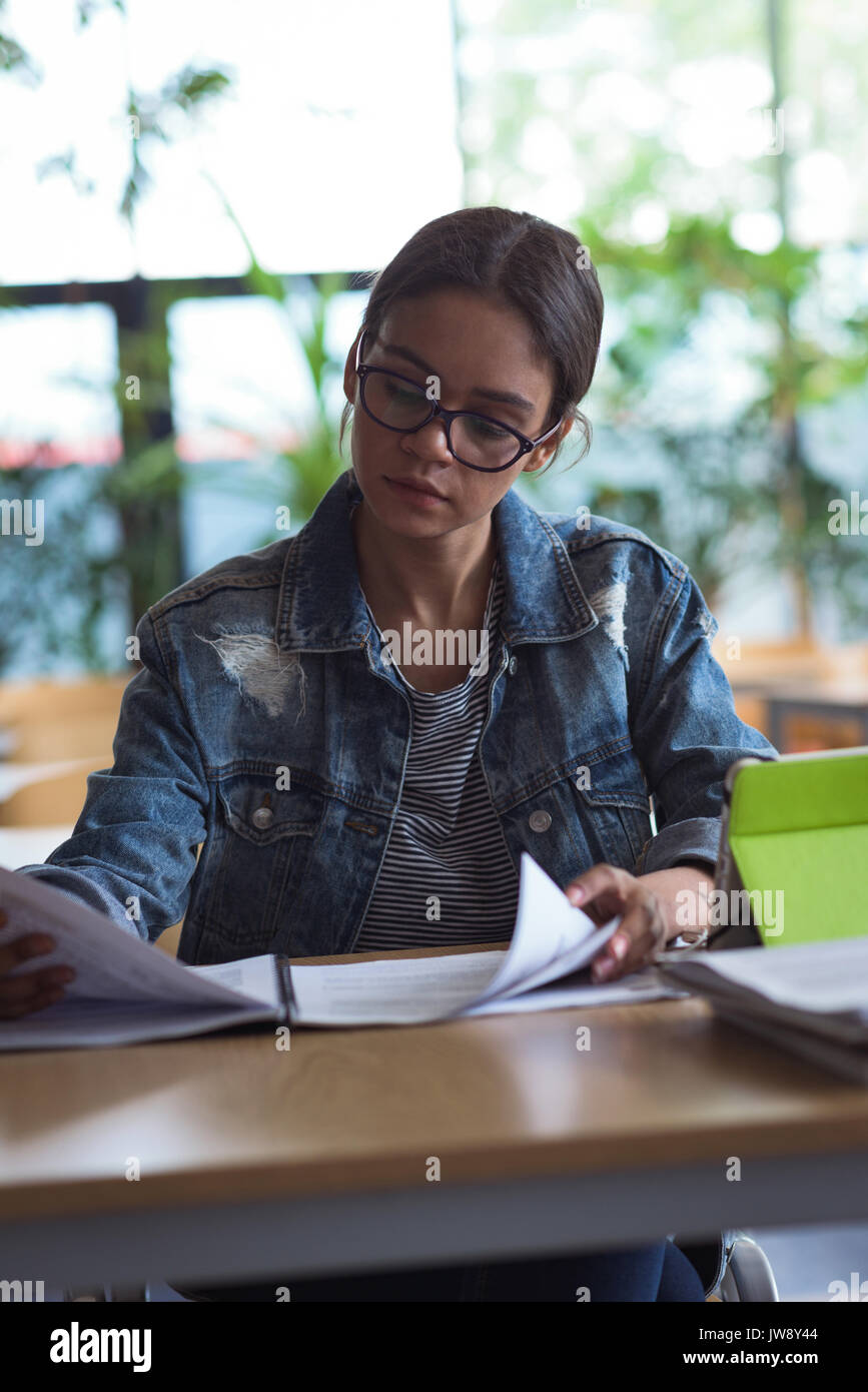 Female university student studying at desk in classroom Stock Photo
