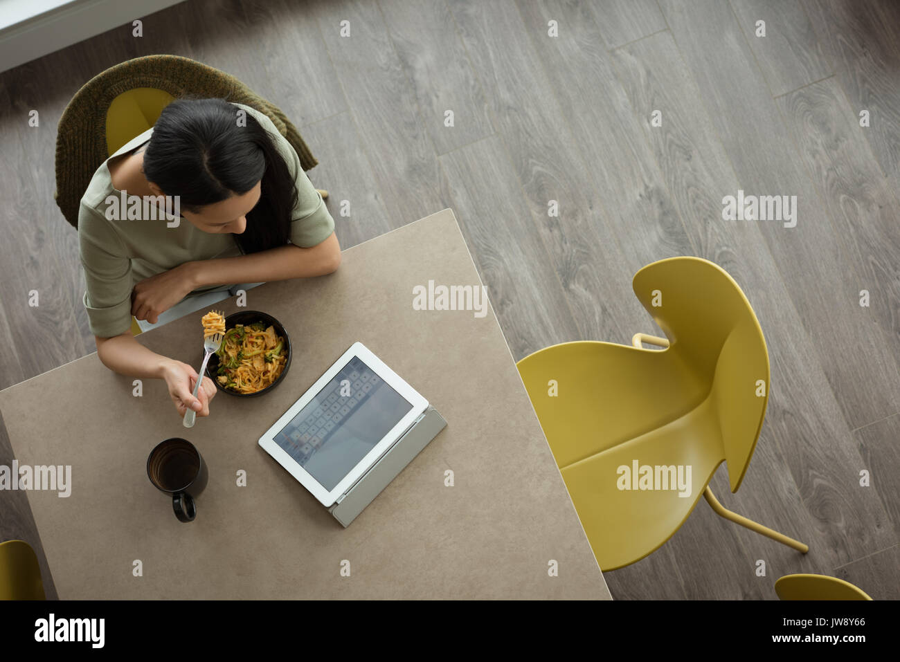 Top view of woman using laptop while having breakfast Stock Photo