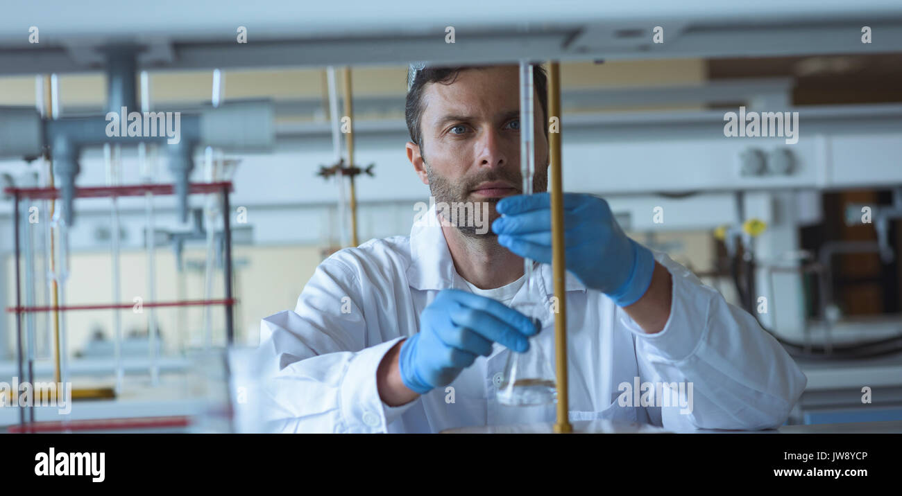 Attentive university student doing a chemical experiment in laboratory Stock Photo