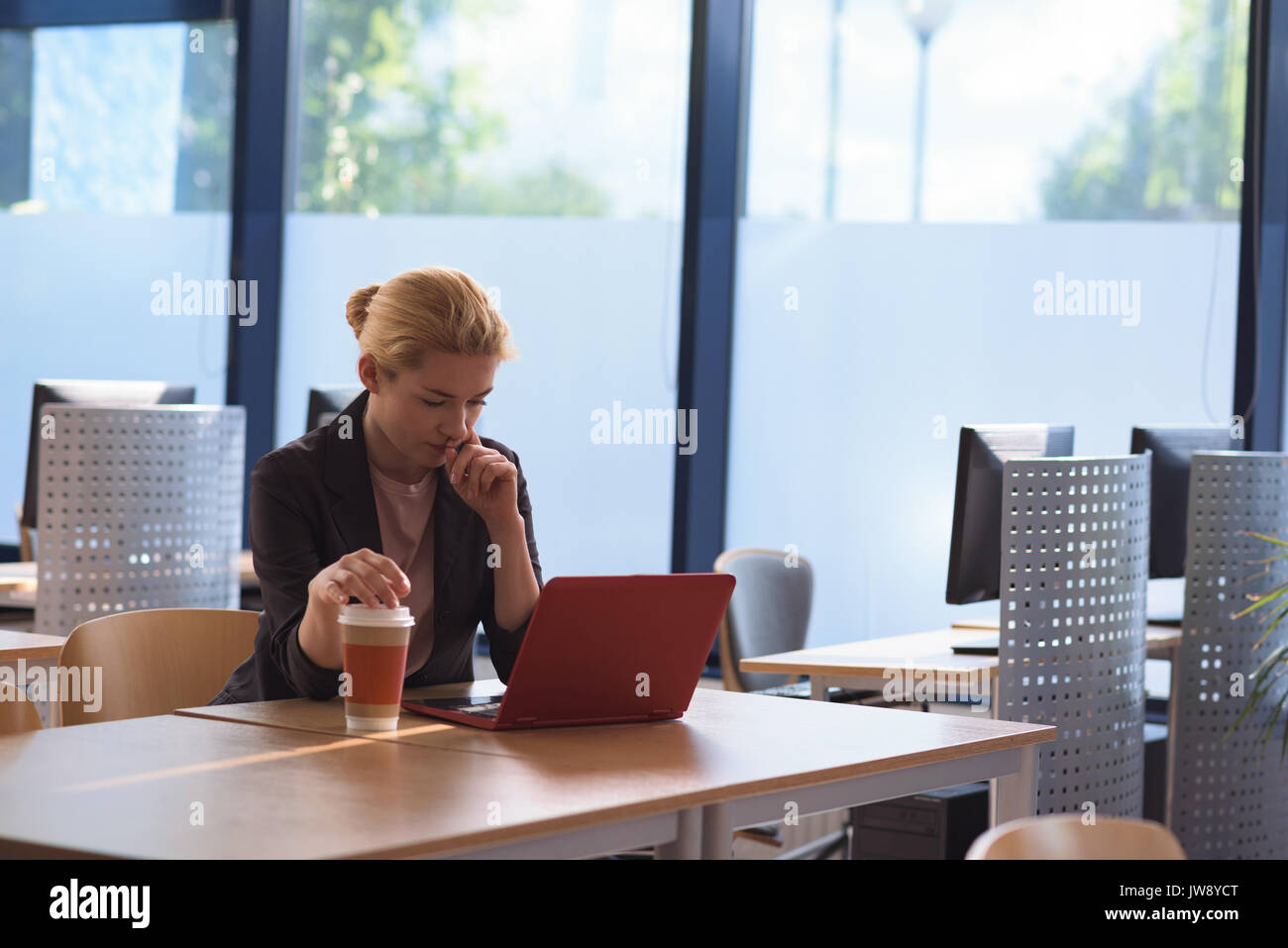 Attentive university student using laptop in college Stock Photo