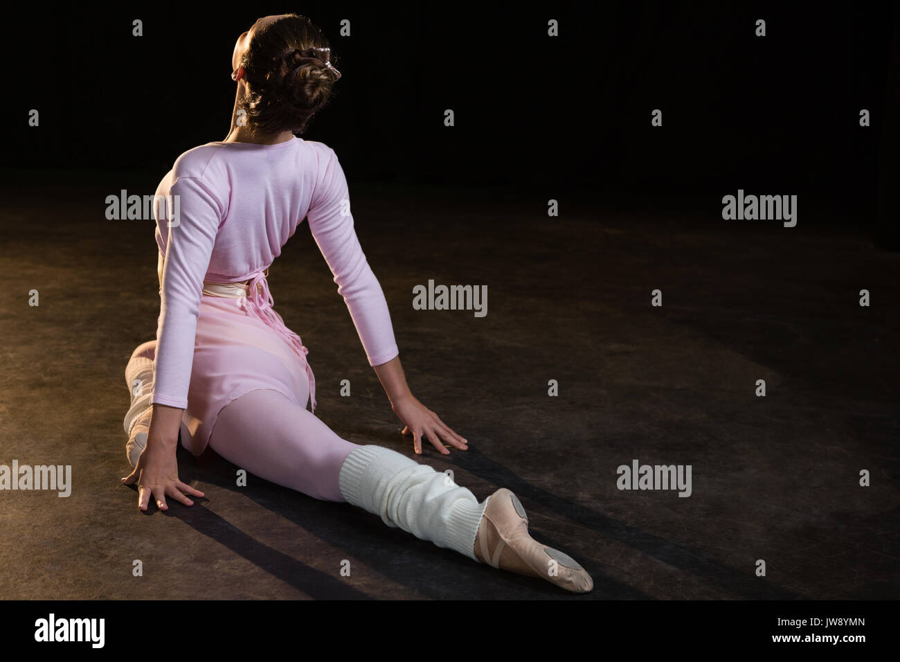 Female ballet dancer stretching before dancing in the studio Stock Photo