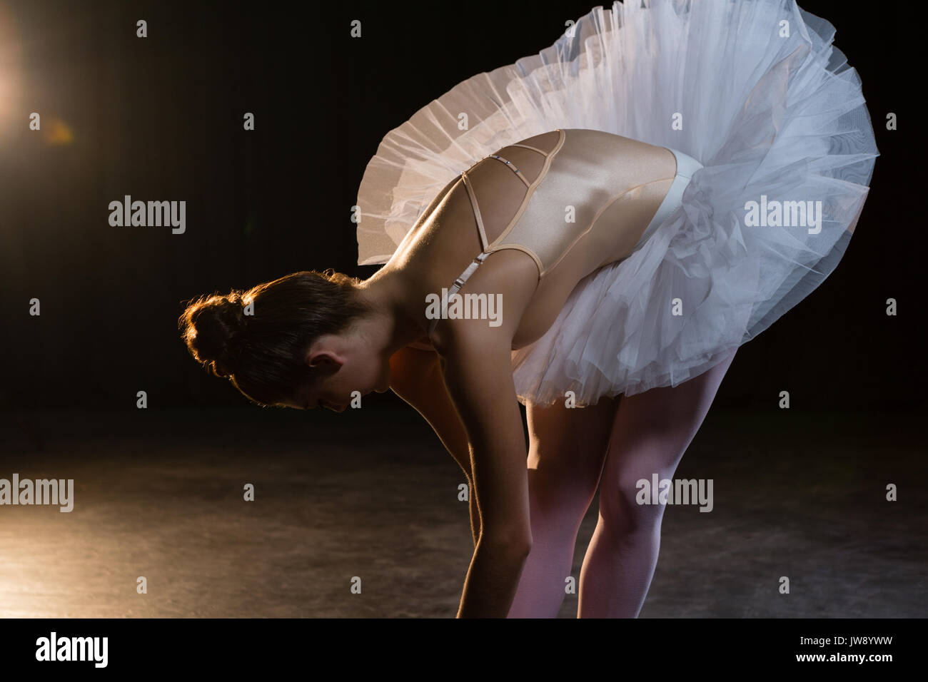 Female ballet dancer stretching before dancing in the studio Stock Photo